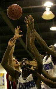 A Palm Springs High School defender (left) and Cathedral City High School's Brian Davis (center) and Anthony Gilchrist (right) reach for the ball during their game on Thursday at Cathedral City High School. The Lions won 78-58, winning the DVL title.