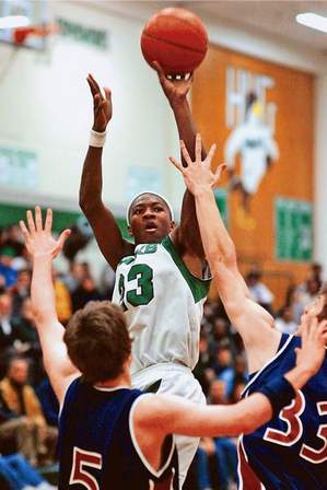 Hug�s Armon Johnson goes up for two points over Reno�s Roger Carlson (5) and Cavin Hill during their game Tuesday night at Hug High. Johnson scored 33 points in the 76-75 Hawks� win, and became the state�s all-time leading scorer.